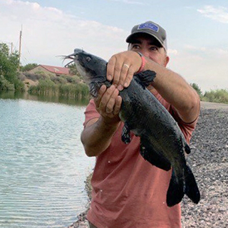 Image of a student holding a fish they caught.