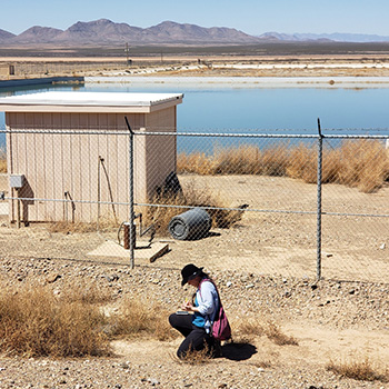 Researcher taking measurements in front of a lake